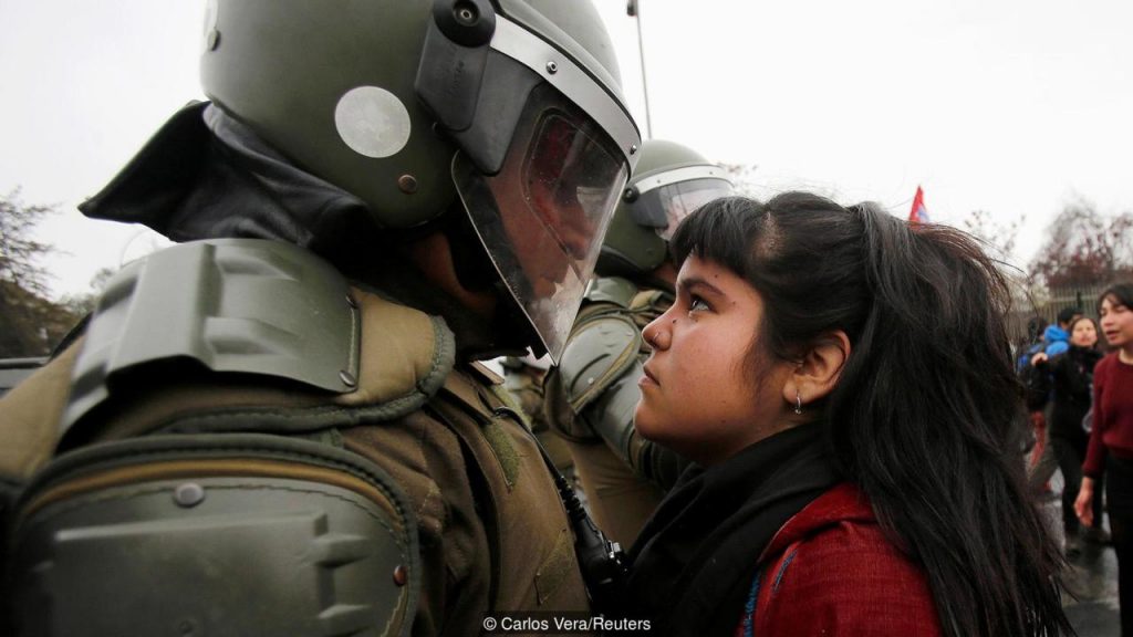 A demonstrator looks at a riot policeman during a protest marking the country's 1973 military coup in Santiago, Chile September 11, 2016. REUTERS/Carlos Vera FOR EDITORIAL USE ONLY. NO RESALES. NO ARCHIVE. TPX IMAGES OF THE DAY
